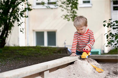 sandbox - Male toddler pushing toy car in sand pit in garden Stock Photo - Premium Royalty-Free, Code: 649-07761259