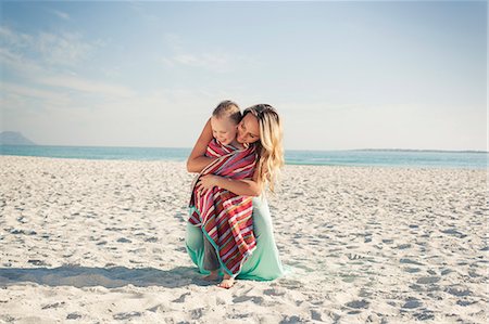 simsearch:649-08306543,k - Mid adult mother wrapping son in a towel at beach, Cape Town, Western Cape, South Africa Stock Photo - Premium Royalty-Free, Code: 649-07804094