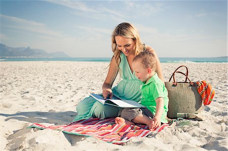 Mid adult mother reading with young son on beach, Cape Town, Western Cape, South Africa Foto de stock - Sin royalties Premium, Código: 649-07804093