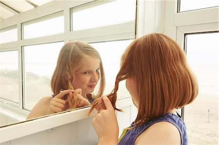 Girl plaiting hair in holiday apartment porch Stock Photo - Premium Royalty-Free, Code: 649-07804102