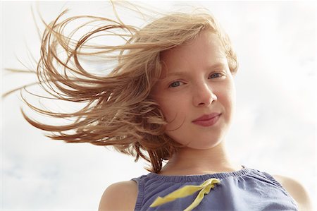 eyes lowered - Portrait of girl with flyaway hair at breezy coast Stock Photo - Premium Royalty-Free, Code: 649-07804103