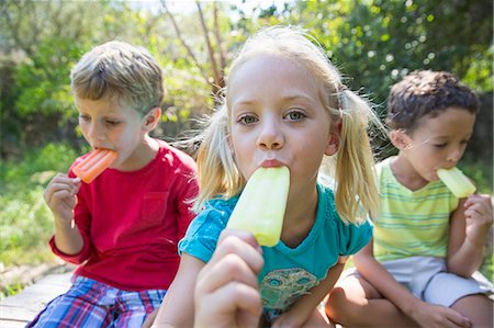 simsearch:614-08219838,k - Portrait of three children in garden eating ice lollies Photographie de stock - Premium Libres de Droits, Code: 649-07804155