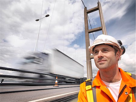 Bridge worker close to traffic on suspension bridge. The Humber Bridge, UK was built in 1981 and at the time was the world's largest single-span suspension bridge Stock Photo - Premium Royalty-Free, Code: 649-07804242