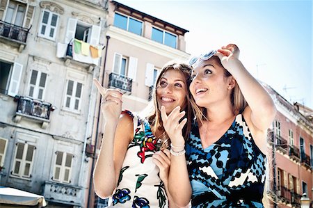 fun fashion street - Two young female friends pointing and looking up on street, Cagliari, Sardinia, Italy Stock Photo - Premium Royalty-Free, Code: 649-07804262