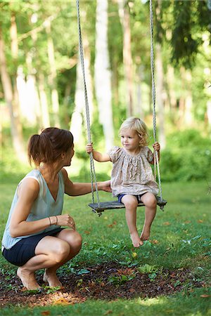 pushing kids on a swing - Mid adult mother and toddler daughter playing on garden swing Stock Photo - Premium Royalty-Free, Code: 649-07804290