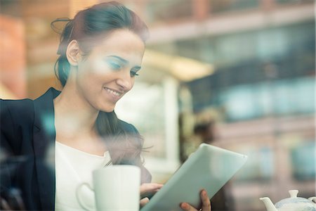 sipping coffee - Young businesswoman using touchscreen on digital tablet in cafe, London, UK Stock Photo - Premium Royalty-Free, Code: 649-07804320