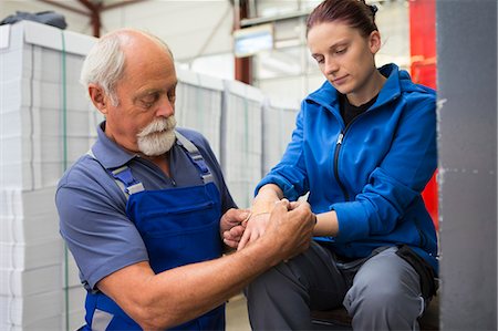 simsearch:649-07804440,k - Factory worker applying first aid to colleague Stock Photo - Premium Royalty-Free, Code: 649-07804438