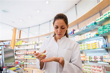 simsearch:649-07804644,k - Pharmacist in pharmacy holding medicine in hand Stock Photo - Premium Royalty-Free, Code: 649-07804639