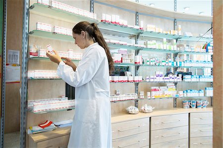 store shelf medicine - Pharmacist in pharmacy looking at medicine box Stock Photo - Premium Royalty-Free, Code: 649-07804632