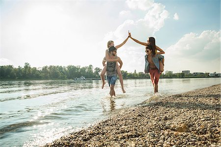 Young men giving young women piggy backs Stock Photo - Premium Royalty-Free, Code: 649-07804715