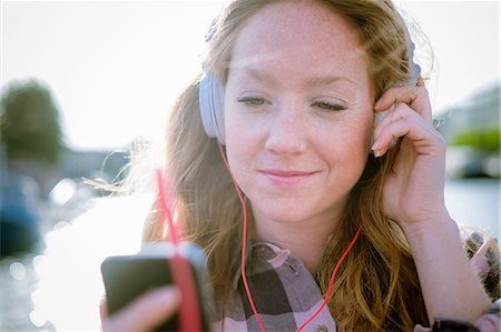simsearch:6108-06167284,k - Close up of young woman listening to music on headphones on street Foto de stock - Sin royalties Premium, Código: 649-07804826