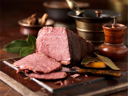 rustic food meal table - Christmas dinner. Dry cured pieced salt beef joint with  orange leaves Stock Photo - Premium Royalty-Free, Code: 649-07804835