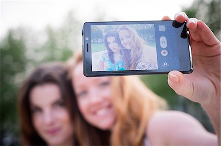 simsearch:614-07735535,k - Close up of two young female friends taking selfie on smartphone in park Photographie de stock - Premium Libres de Droits, Code: 649-07804830