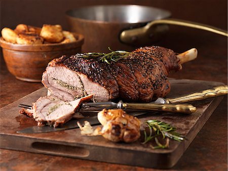Christmas dinner. Roasted rosemary and garlic leg of lamb and roast potatoes Photographie de stock - Premium Libres de Droits, Code: 649-07804841