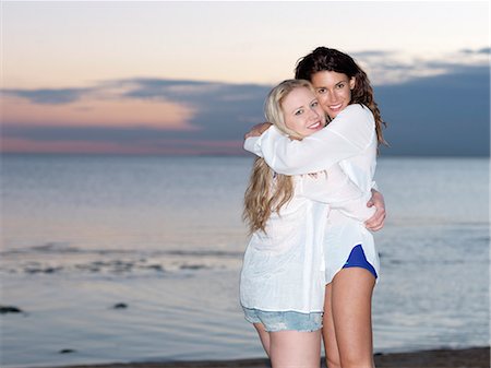 Portrait of two young women friends hugging on beach at dusk, Williamstown, Melbourne, Australia Stock Photo - Premium Royalty-Free, Code: 649-07804935