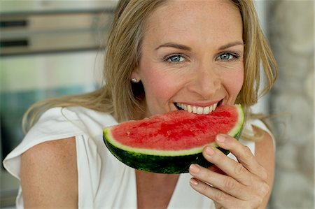 simsearch:649-07905189,k - Mature woman biting watermelon Photographie de stock - Premium Libres de Droits, Code: 649-07805000