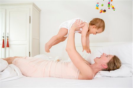 simsearch:614-06312011,k - Mother lifting baby daughter on bed Photographie de stock - Premium Libres de Droits, Code: 649-07805126