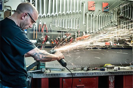 sfregare - Male mechanic grinding metal in workshop Fotografie stock - Premium Royalty-Free, Codice: 649-07803226