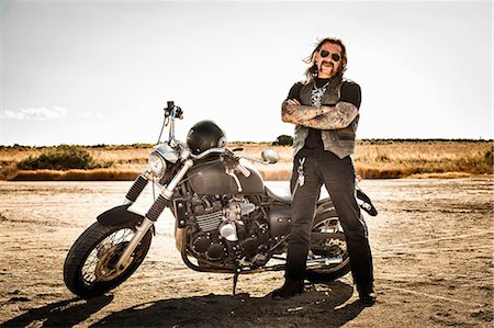 Portrait of mature male motorcyclist on arid plain, Cagliari, Sardinia, Italy Stock Photo - Premium Royalty-Free, Code: 649-07803237