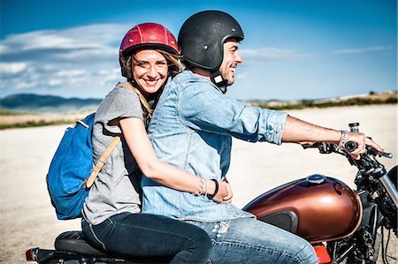 riding bikes in the summer - Mid adult couple riding motorcycle on arid plain, Cagliari, Sardinia, Italy Stock Photo - Premium Royalty-Free, Code: 649-07803233