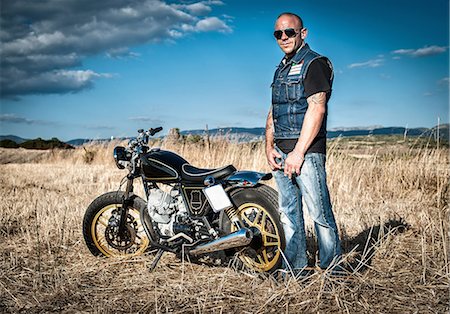 sunlight jeans - Portrait of male motorcyclist in plain landscape, Cagliari, Sardinia, Italy Stock Photo - Premium Royalty-Free, Code: 649-07803246