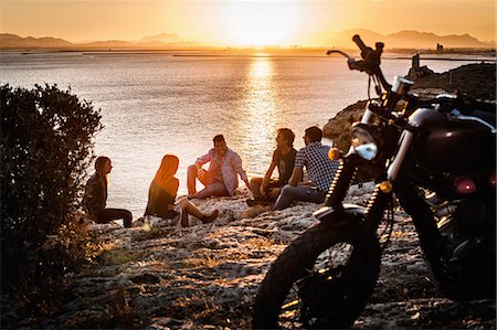 Five motorcycling friends taking a break on coast at sunset, Cagliari, Sardinia, Italy Photographie de stock - Premium Libres de Droits, Code: 649-07803248