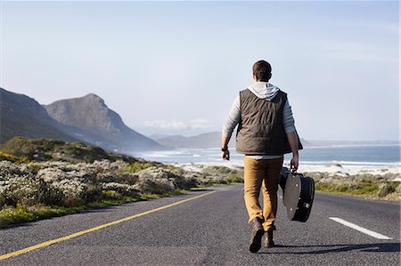 simsearch:649-07803262,k - Rear view of young man with guitar case walking on coastal road, Cape Town, Western Cape, South Africa Stock Photo - Premium Royalty-Free, Code: 649-07803259