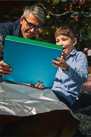 person opening shirt - Father on sitting room floor opening christmas gifts with son Stock Photo - Premium Royalty-Free, Code: 649-07803312