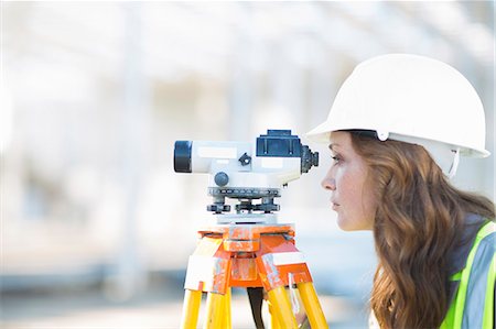 Female surveyor looking through level on construction site Photographie de stock - Premium Libres de Droits, Code: 649-07803330