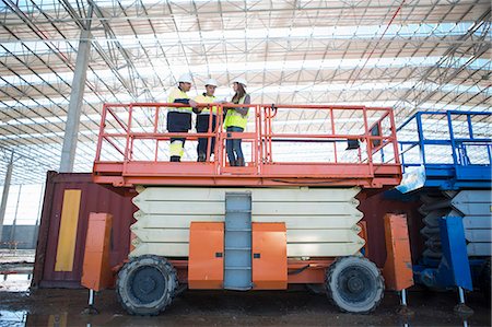 Low angle view of site managers and architect on viewing platform on construction site Fotografie stock - Premium Royalty-Free, Codice: 649-07803333