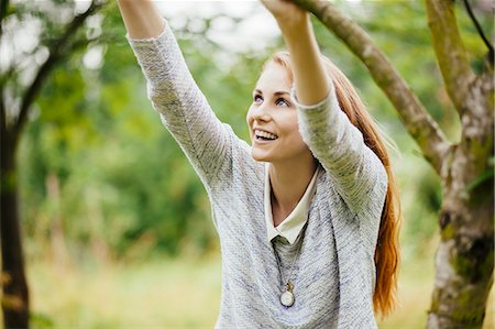 person nature not illustration and one person - Young woman in field holding on to tree branch Stock Photo - Premium Royalty-Free, Code: 649-07803348