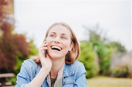 people laughing smart phones outdoor - Young woman laughing whilst chatting on smartphone in park Photographie de stock - Premium Libres de Droits, Code: 649-07803357