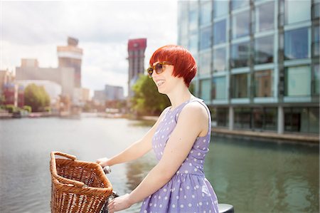 portrait and one person and happy and young adult - Woman pushing bike along canal, East London, UK Stock Photo - Premium Royalty-Free, Code: 649-07803399