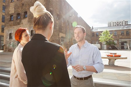 step (action, stepping on something) - Three young people talking, building in background, East London, UK Photographie de stock - Premium Libres de Droits, Code: 649-07803414