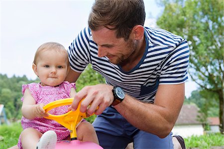 simsearch:649-07520662,k - Mid adult man with baby daughter on toy car  in garden Photographie de stock - Premium Libres de Droits, Code: 649-07803431