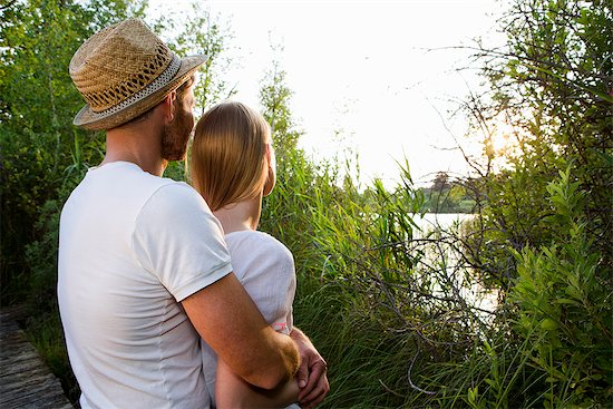 Romantic mid adult couple watching lakeside sunset Stock Photo - Premium Royalty-Free, Image code: 649-07803456