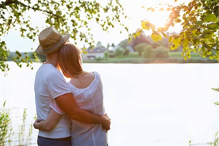 simsearch:649-07239730,k - Rear view of mid adult couple watching sunset over lake Foto de stock - Sin royalties Premium, Código: 649-07803458