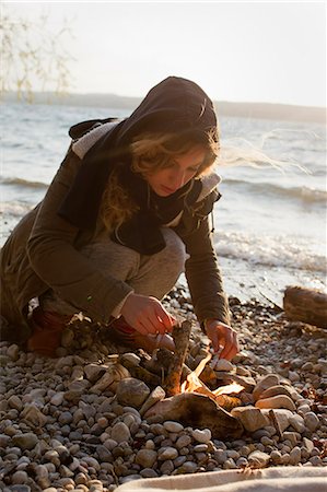 firewood - Woman making a fire by seaside Foto de stock - Sin royalties Premium, Código: 649-07803513