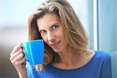 simsearch:649-07803570,k - Portrait of mid adult businesswoman leaning against glass wall drinking coffee Foto de stock - Sin royalties Premium, Código: 649-07803573