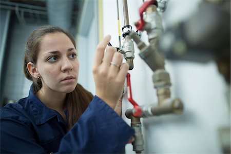 fabrikarbeiter - Female engineer turning pipe valve in factory Foto de stock - Sin royalties Premium, Código: 649-07803724