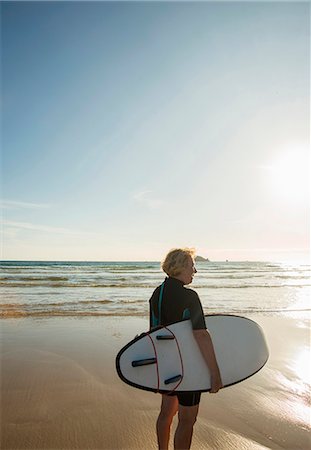 senior woman alone thinking - Senior female surfer standing on beach with surfboard, Camaret-sur-mer, Brittany, France Stock Photo - Premium Royalty-Free, Code: 649-07803862