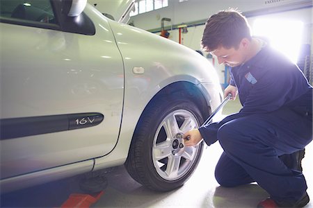 Male student mechanic tightening car wheel in college garage Photographie de stock - Premium Libres de Droits, Code: 649-07803895