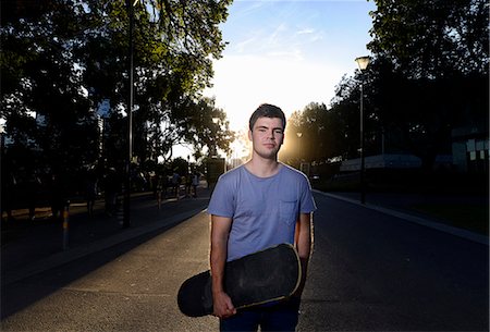 simsearch:649-06622240,k - Portrait of young man holding skateboard Photographie de stock - Premium Libres de Droits, Code: 649-07803945