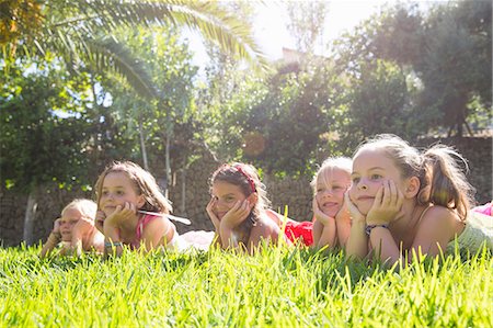 Five girls lying in a row in garden with chins on hands Stock Photo - Premium Royalty-Free, Code: 649-07803968