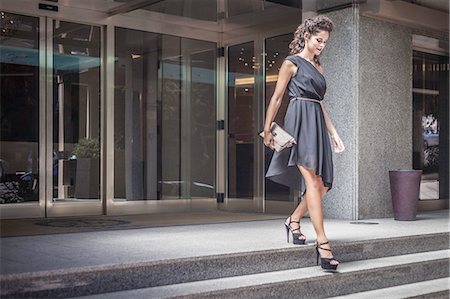 simsearch:649-07647894,k - Young woman wearing black dress going down steps Foto de stock - Sin royalties Premium, Código: 649-07904904