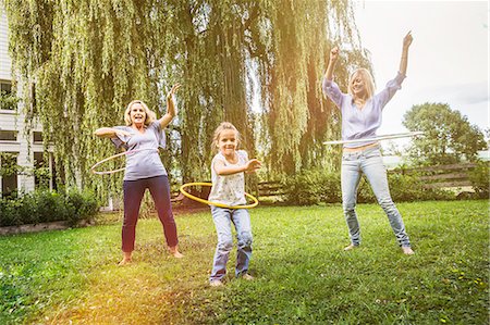 Female members of family playing with hula hoop Stock Photo - Premium Royalty-Free, Code: 649-07905158