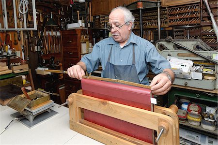 Senior man measuring book spine in traditional bookbinding workshop Stock Photo - Premium Royalty-Free, Code: 649-07905311