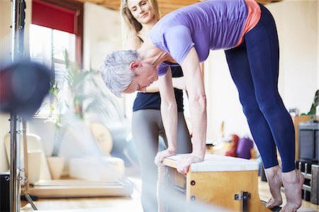 soporte (físico) - Mature female student bending over combo chair in pilates gym Foto de stock - Sin royalties Premium, Código: 649-07905368