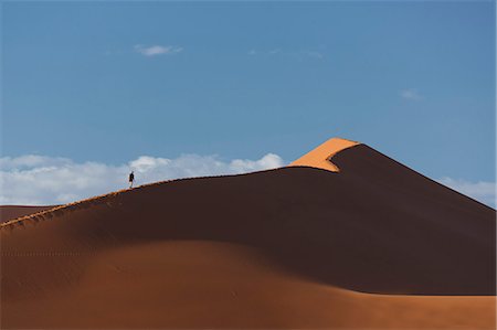 Silhouetted man climbing giant sand dune, Sossusvlei National Park, Namibia Photographie de stock - Premium Libres de Droits, Code: 649-07905424