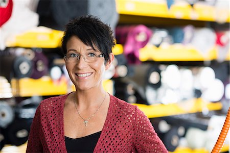 simsearch:649-07905510,k - Portrait of mature seamstress in front of textile shelves in workshop Stock Photo - Premium Royalty-Free, Code: 649-07905504